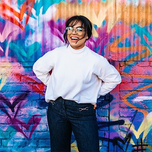 woman standing in front of multicolored wall