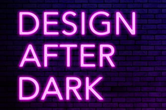 The text 'Design After Dark' is illuminated in fluro pink, in front of a purple brick wall. 