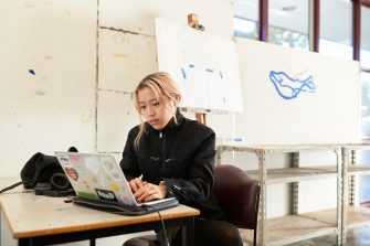 Arts student working in the studio on a laptop