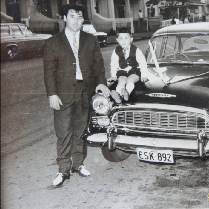 An image of a guy and a boy dressed up  next to a 1960s Humber 