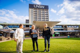 Image shows ADA's Indigenous support officer and students on the library lawn 