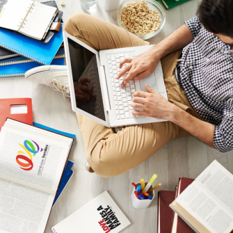 Man on computer with book called Love makes a family beside him