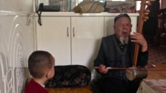 Ömär-Qari's grandson listens to his grandfather sing at home, 2014