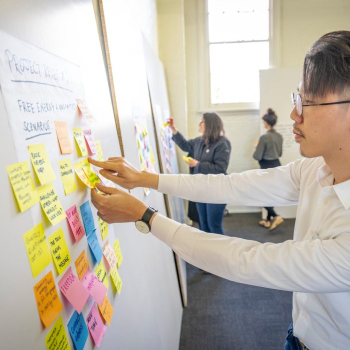 Person placing sticky note on display board