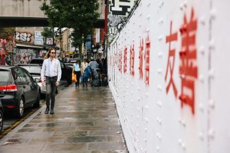 A man walking past the Brick Lane graffiti wall