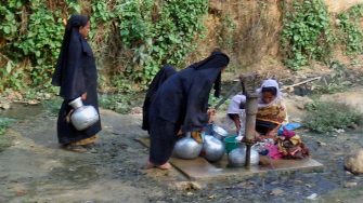 Women gathering water from a well