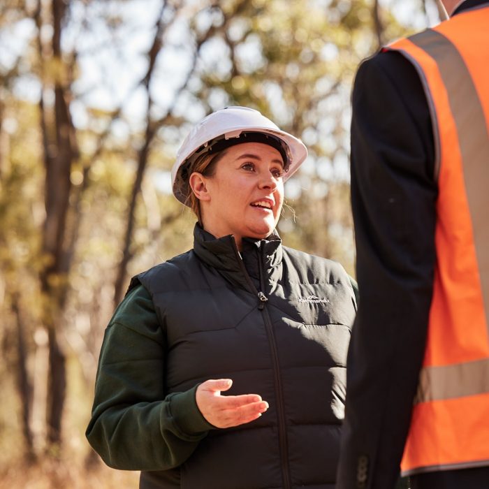 Camille in a hard hat in the field 