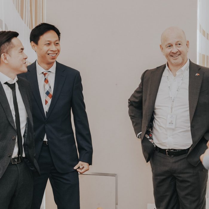 Group shot of 4 men chatting and smiling at a UNOVA event