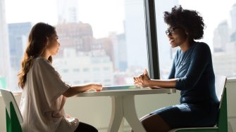 Two women sitting at a table and talking