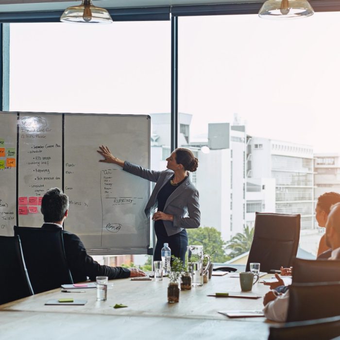 Shot of an executive giving a whiteboard presentation to a group of colleagues in a boardroom