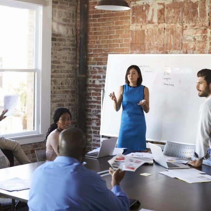 Businesswoman At Whiteboard In Brainstorming Meeting