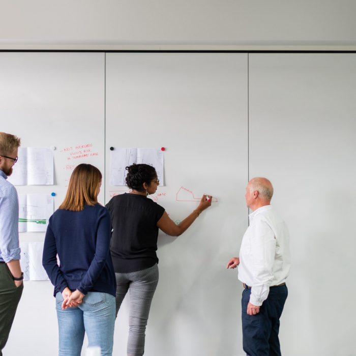 People standing in front of white board