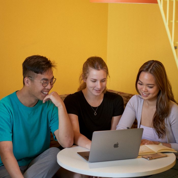 Students talking and laughing at "The Place" inside the business school at UNSW.