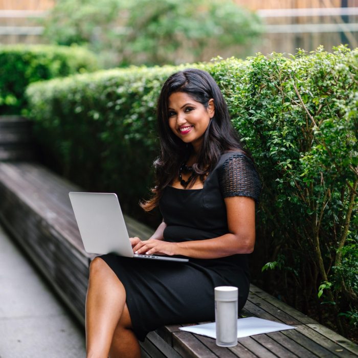 Woman sitting on bench with laptop