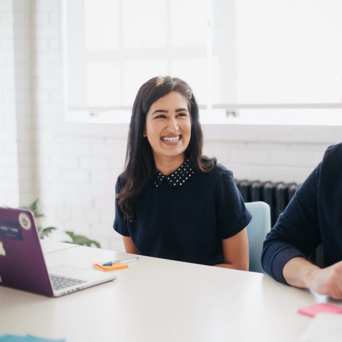 Two people smiling while discussing