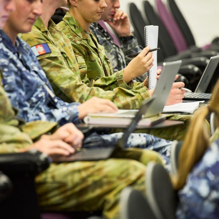 Defence students sitting with laptops