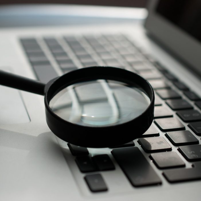 Magnifying glass on laptop keyboard