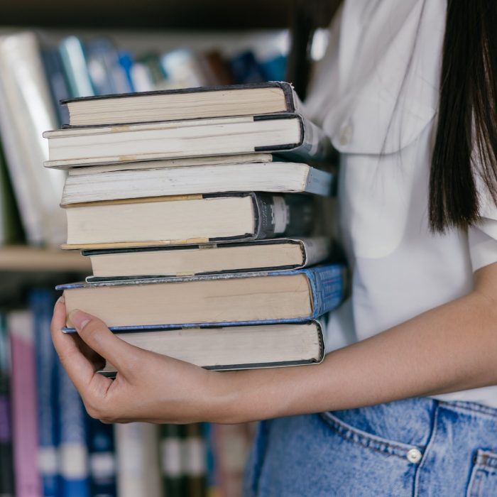 Woman holding stack of books