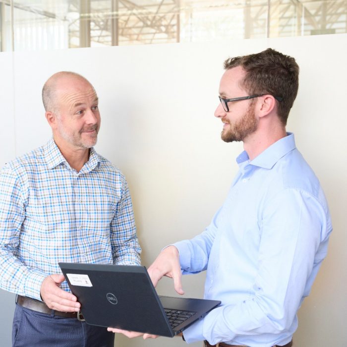 Two men looking at a laptop