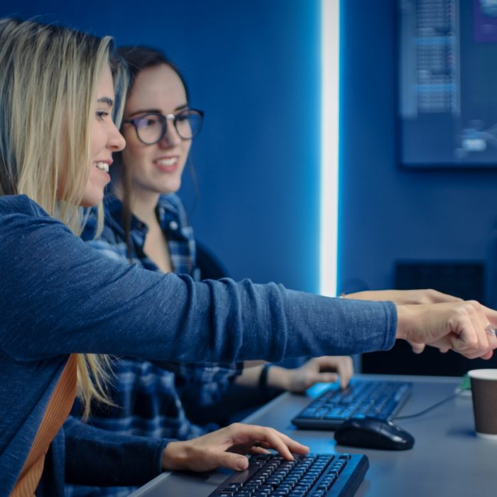 Two Female IT Programers Working on Desktop Computer in Data Center System Control Room. Team of Young Professionals In Software and Hardware Development, Doing Coding