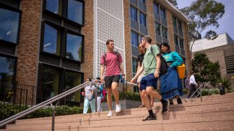 A group of students chatting while walking down the stairs by Globe Lawn on Kensington Campus