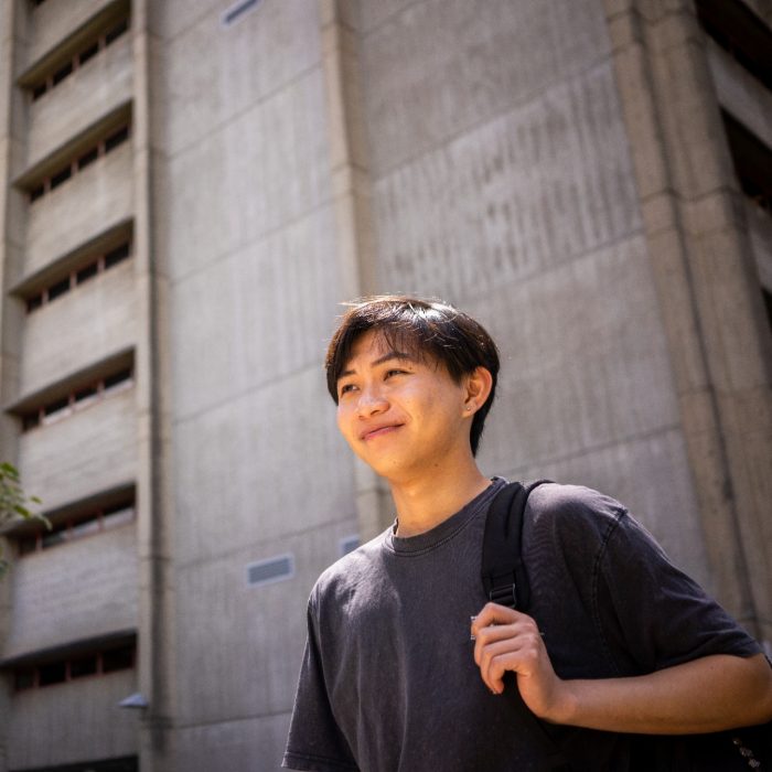 A student stands against the backdrop of the UNSW Main Library buidling