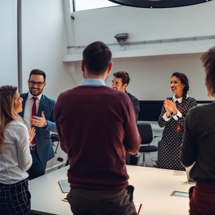 Shot of a group of coworkers applauding after a successful presentation in a boardroom