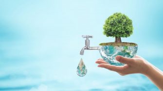Person holding the Earth with a tree on top and a tap coming out of the Earth