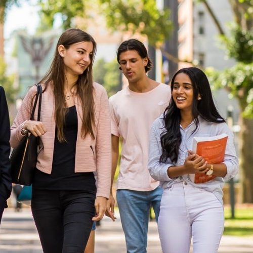 4 Students walking and talking on campus