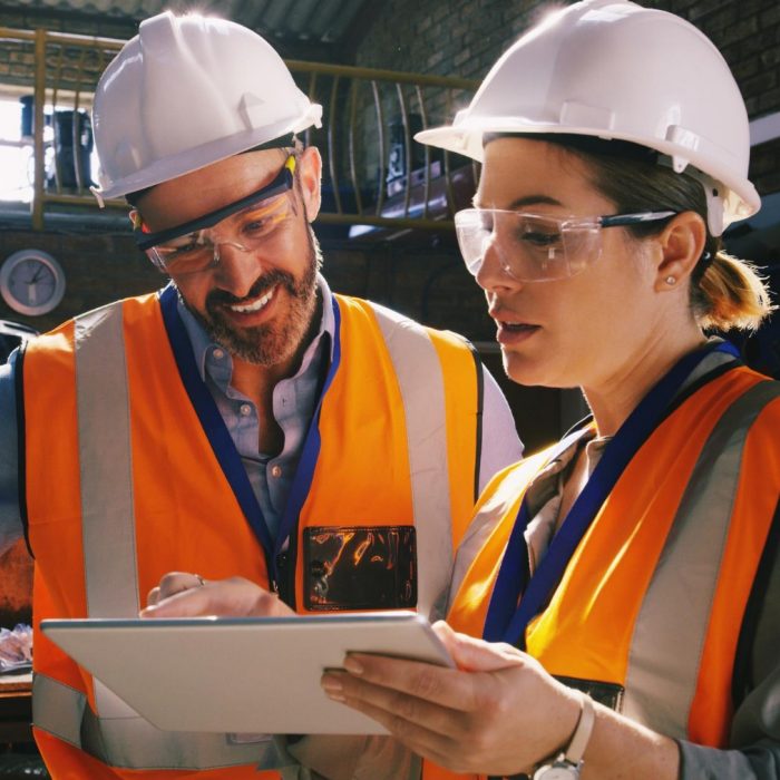 Man and woman wearing hard hats and high vis