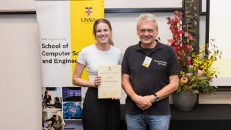 Student with award stands with mentor