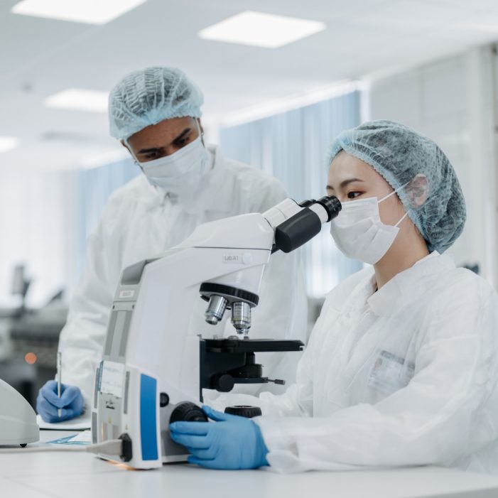 Two scientists working at a microscope