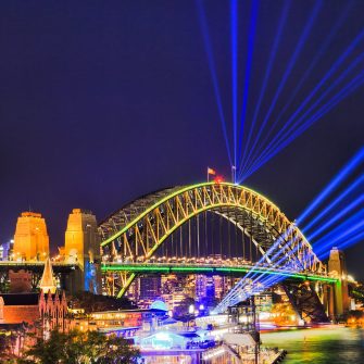 The Sydney Harbour bridge arch during Vivid Sydney light show and festival illuminated with bright blue laser beams in dark night sky