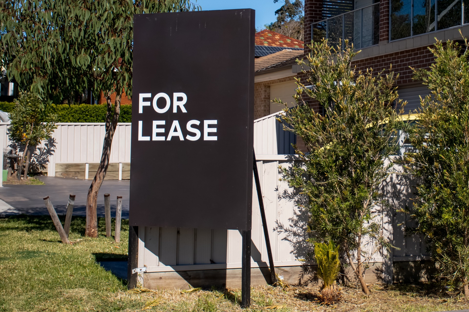 For lease sign on a blue display outside of a resedential building in Australia. Investment property real estate concept