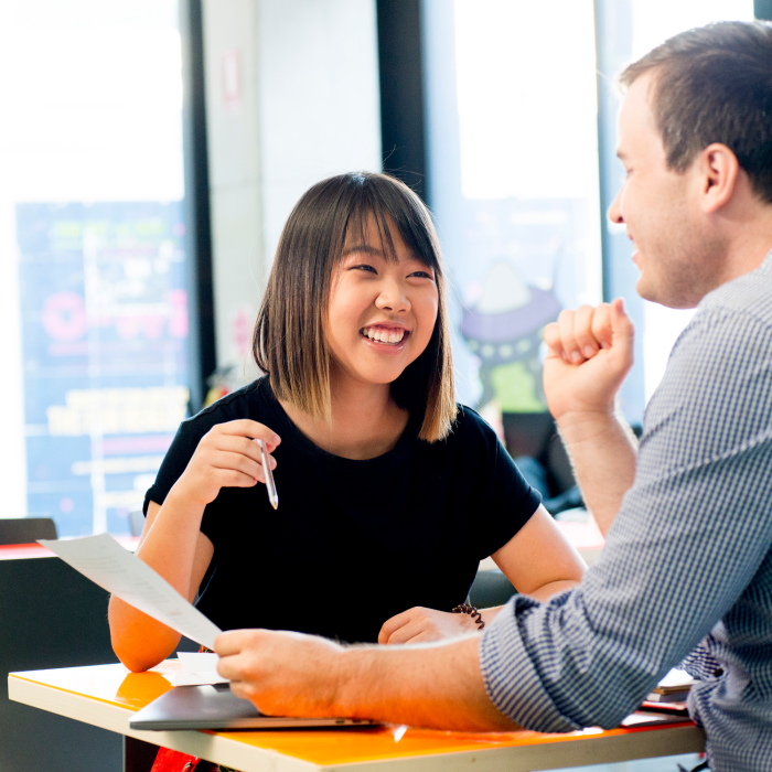 Photograph of a conversation between two adults discussing the disability inclusion plan