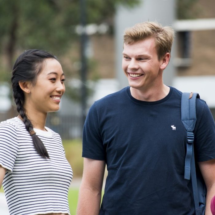 A group of three students smiling at each other