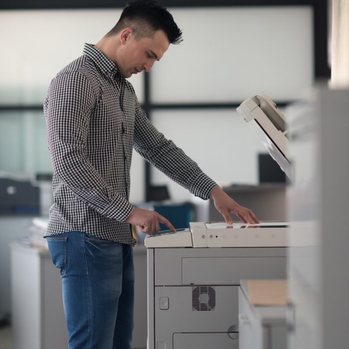 young business man copy documents on copy machine at modern startup office interior, casual clothes