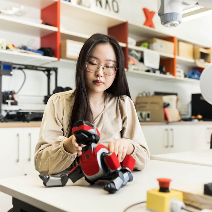 Computer Science Student working with Robotic dog in lab