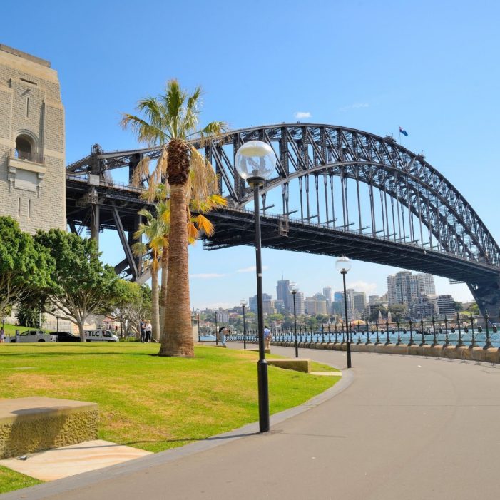 Side view of Sydney Harbour bridge in bright blue sky.