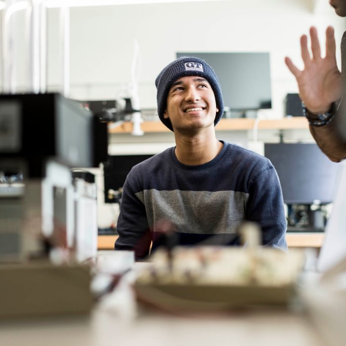 Students work with a lecturer to understand sophisticated practical telecommunications equipment