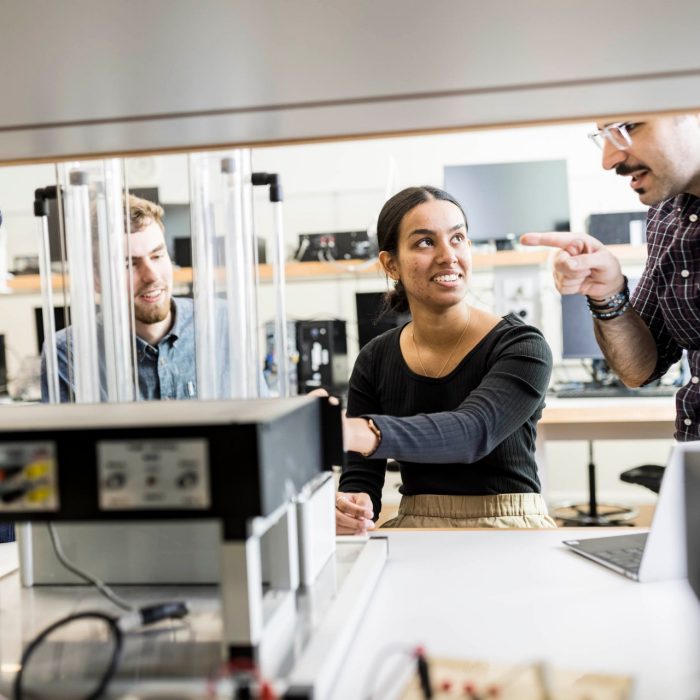 Students work with a lecturer to understand sophisticated practical telecommunications equipment