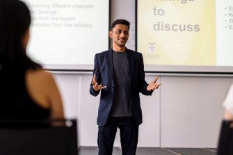 Business school student presenting in front of a classroom