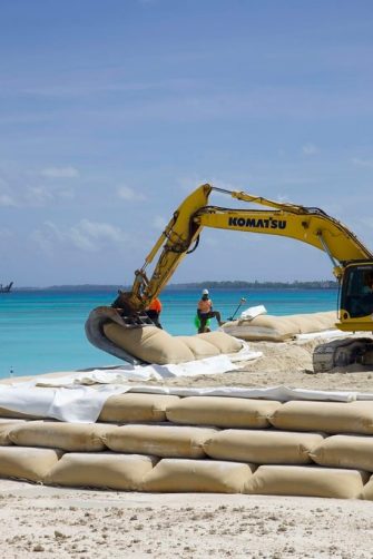 Bulldozer places sand bags on beach in Funafuti