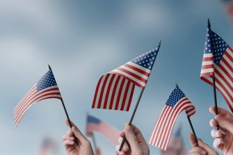 A group of people holding small flags of the USA in their hands.