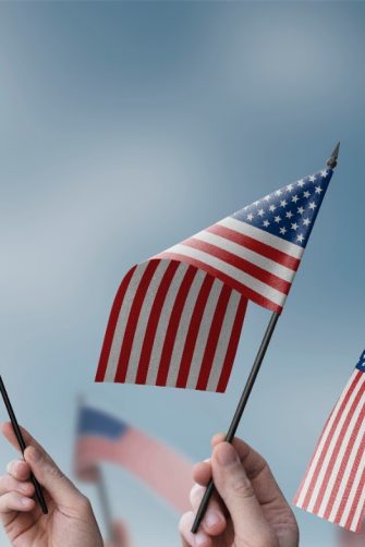 A group of people holding small flags of the USA in their hands.