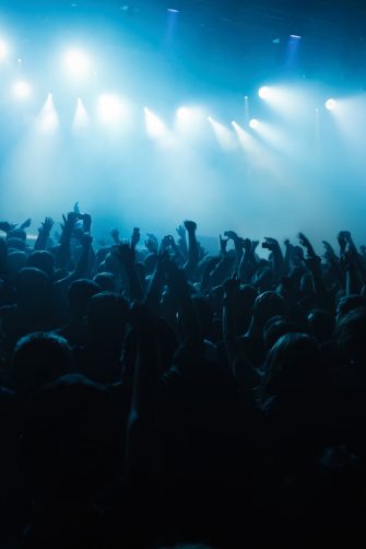 Concert crowd raving to the music. Big group of young people partying on musical festival in night club