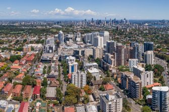 An aerial shot of an area of Western Sydney characterised by houses set closely together with narrow roads, little vegetation and dark roofs