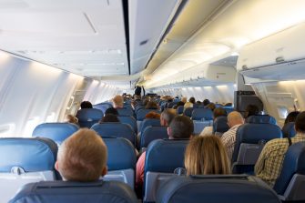 Interior of airplane with passengers on seats waiting for take off from airport. Vacation concept