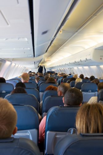 Interior of airplane with passengers on seats waiting for take off from airport. Vacation concept