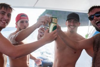 Portrait of a group of guys drinking beer while on a boat at sea.